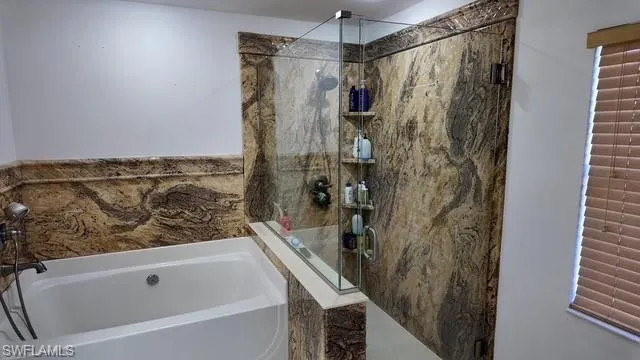 Full bath with a garden tub and a marble finish shower