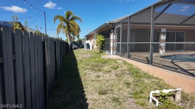Fenced backyard with a lanai and a sunroom