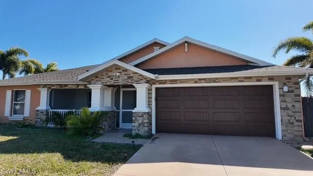Craftsman-style house with a front lawn, driveway, and a garage