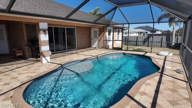 View of swimming pool with patio surround, a sunroom, and a lanai