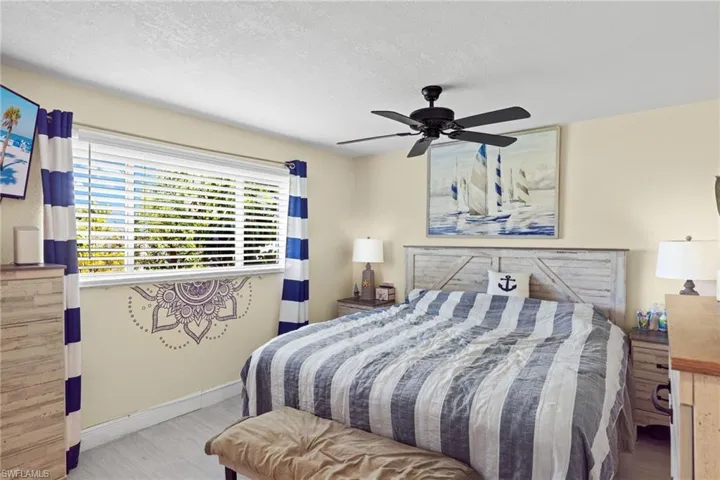 Bedroom with a textured ceiling and ceiling fan