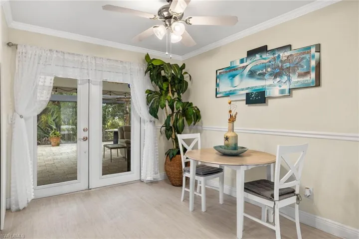 Dining room with ceiling fan, ornamental molding, and light hardwood / wood-style flooring