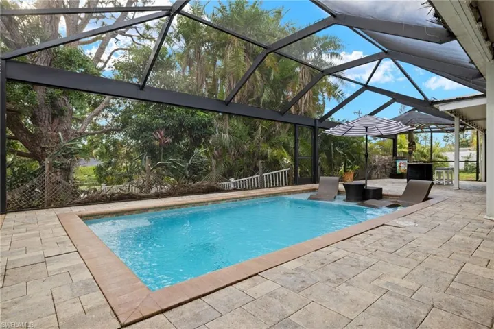 View of swimming pool featuring a patio area and glass enclosure