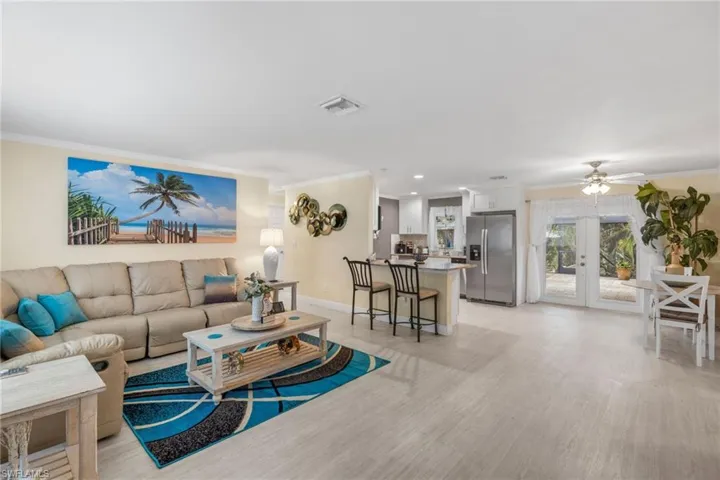 Living room with french doors, light hardwood / wood-style floors, crown molding, and ceiling fan