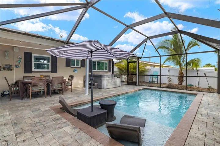 View of pool with a patio and glass enclosure