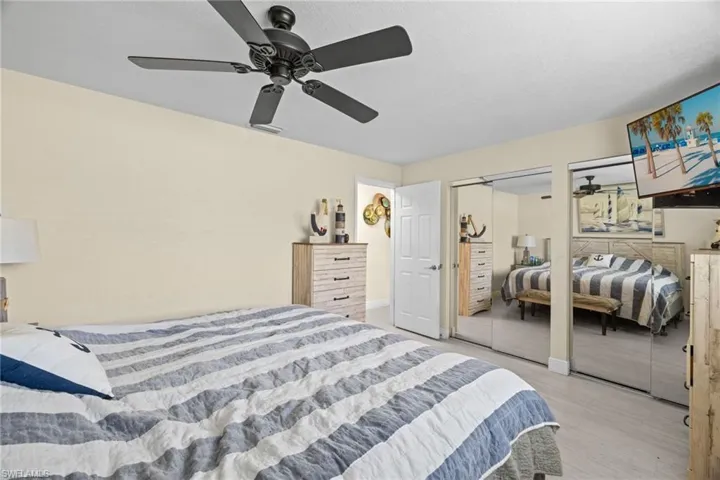 Bedroom featuring two closets, light wood-type flooring, and ceiling fan
