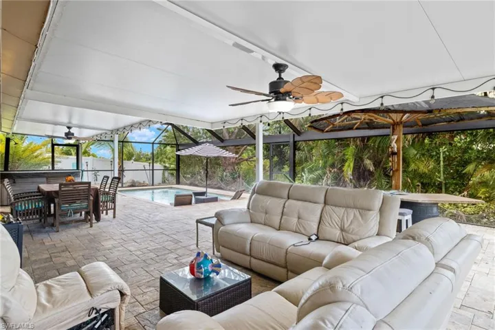 View of patio featuring an outdoor living space, glass enclosure, and ceiling fan