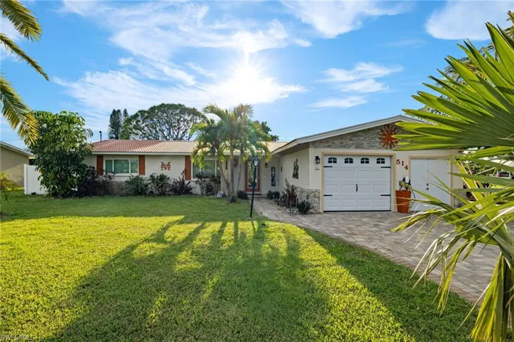 Single story home featuring a front yard and a garage