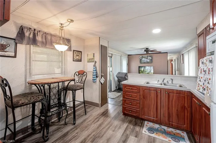 Kitchen featuring hardwood / wood-style flooring, ceiling fan, sink, and pendant lighting