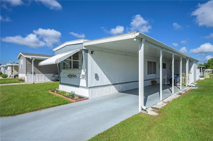 View of home's exterior with a yard and a carport