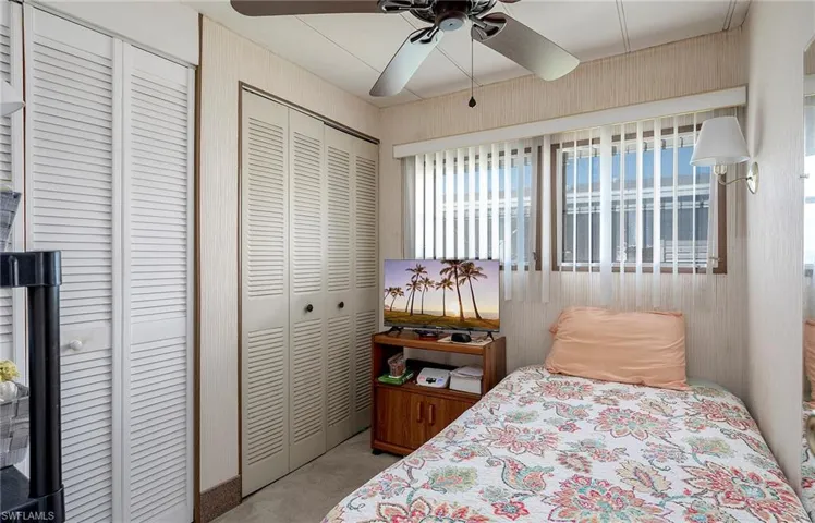Carpeted bedroom with two closets and ceiling fan