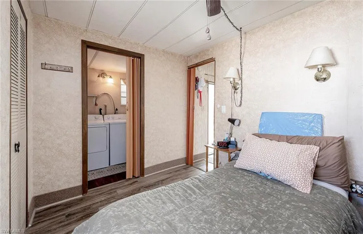 Bedroom with hardwood / wood-style flooring, ceiling fan, and independent washer and dryer