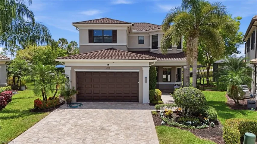 Stucco exterior with a tile roof, featuring a two-car garage with a paneled door