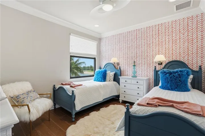 Spacious room featuring wood-finish flooring and a decorative accent wall