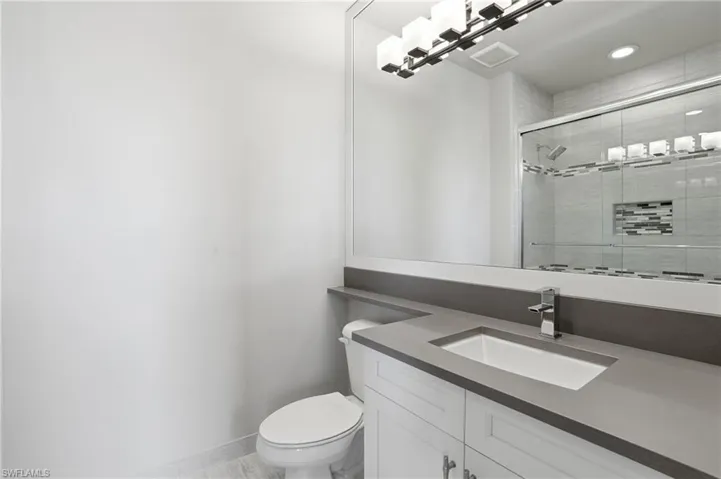Bathroom vanity featuring a rectangular undermount sink, gray countertop, and chrome faucet