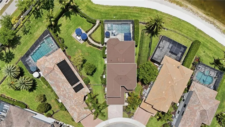 Aerial view showcasing a cul-de-sac home with a screened pool enclosure and private driveway