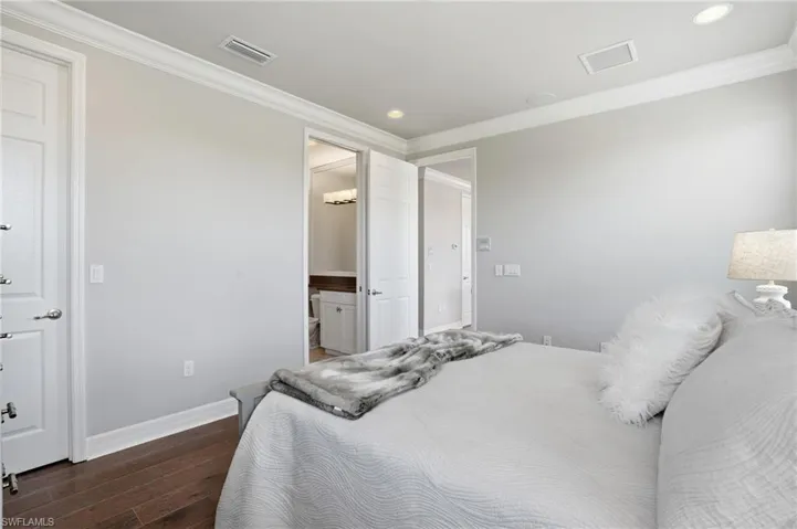 Bedroom featuring wood-finish flooring, crisp white trim, and recessed lighting