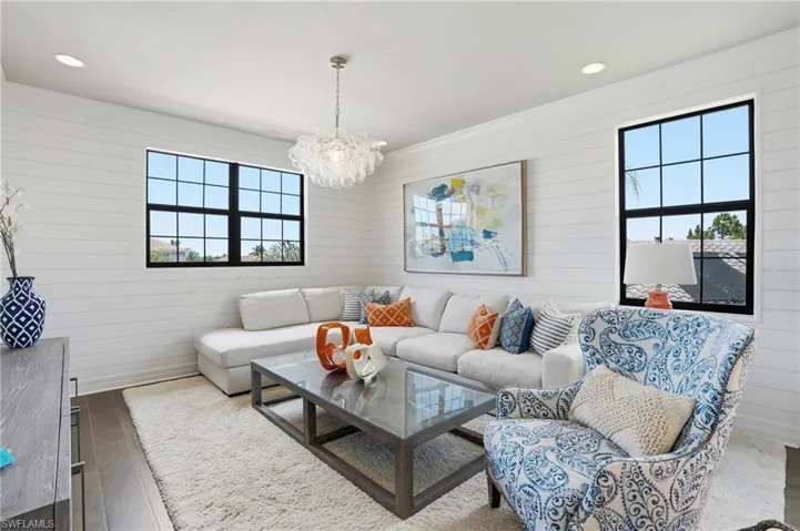 Living area featuring horizontal shiplap wall paneling, dark wood-finish flooring, and recessed ceiling lighting