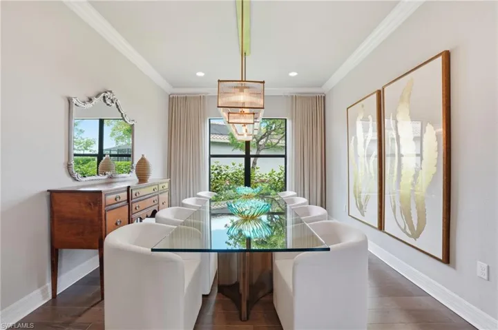 Formal dining space featuring wood-finish flooring, crown molding, and recessed lighting