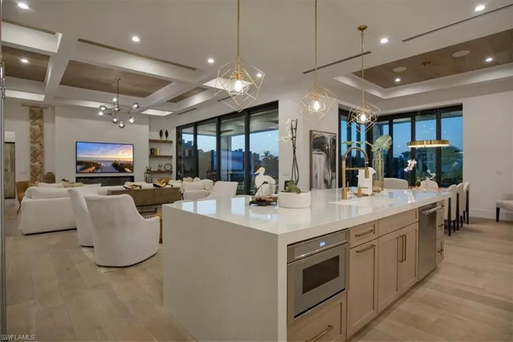 Kitchen featuring open floor plan, a notable chandelier, a sink, and dishwasher