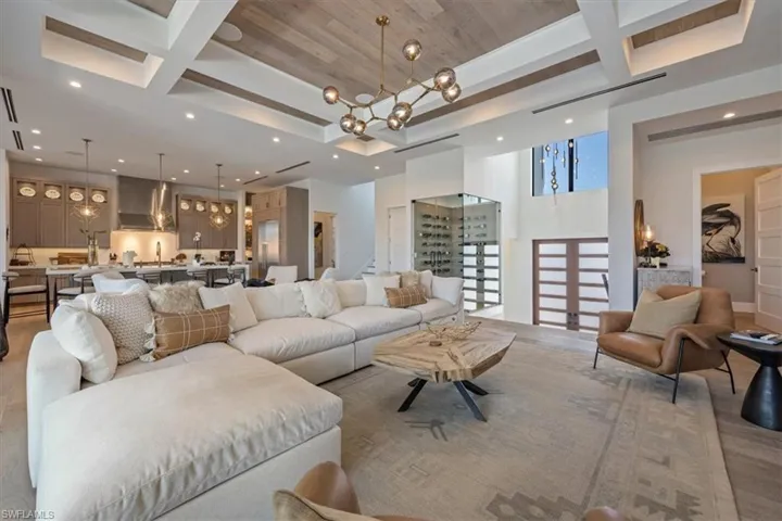 Living area with recessed lighting, coffered ceiling, and a notable chandelier