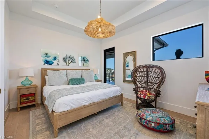 Bedroom with baseboards, wood finished floors, and multiple windows