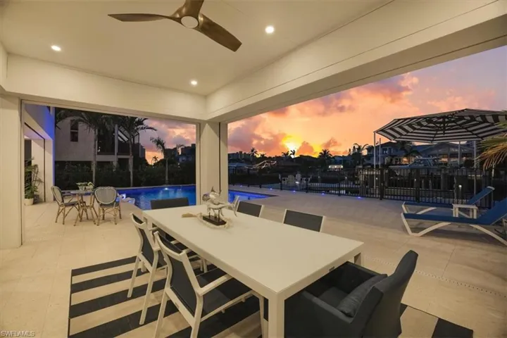 Patio terrace at dusk featuring a fenced in pool, a ceiling fan, and outdoor dining area