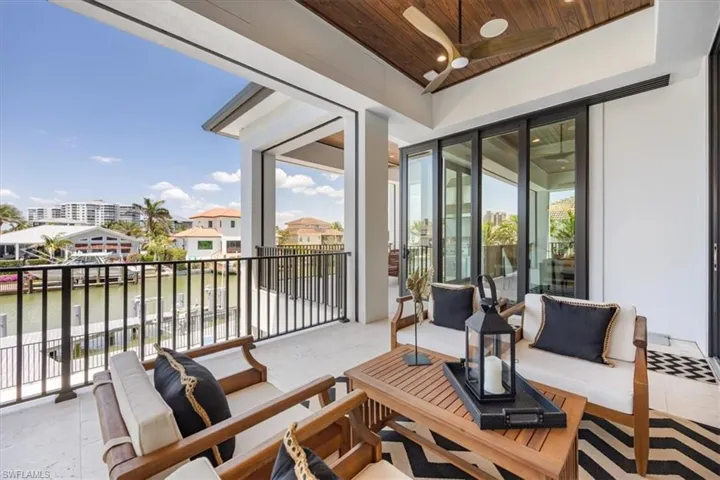 Balcony featuring a ceiling fan, a water view, and an outdoor living space