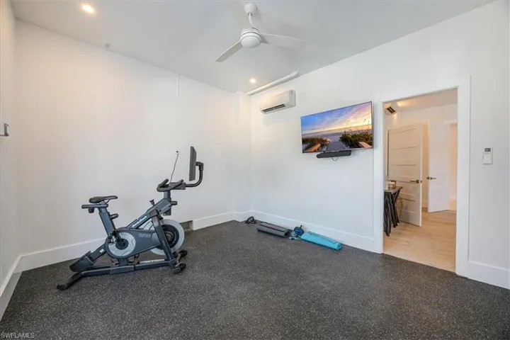 Workout area featuring an AC wall unit, a ceiling fan, and recessed lighting