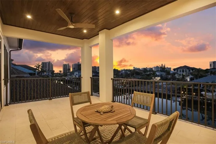 Balcony at dusk featuring a view of city and ceiling fan
