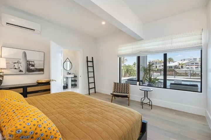 Bedroom featuring a wall mounted AC, wood finished floors, and recessed lighting
