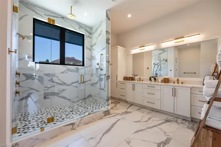 Bathroom featuring double vanity, a sink, marble finish floor, a marble finish shower, and recessed lighting
