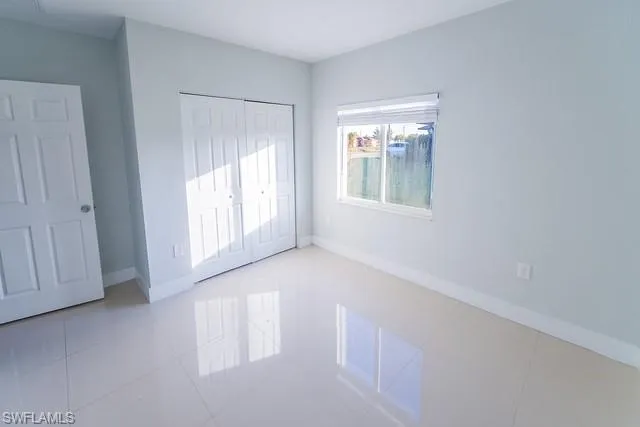 Unfurnished bedroom with light tile patterned floors and a closet
