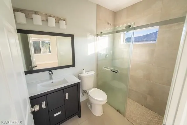 Bathroom featuring vanity, a shower stall, and light tile patterned flooring