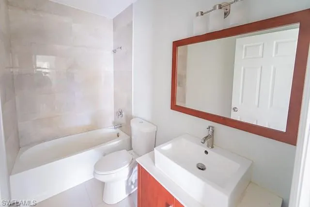 Bathroom with vanity, shower / bath combination, and tile patterned floors