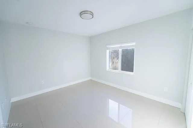 Spare room featuring baseboards and light tile patterned flooring