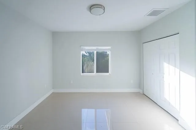 Unfurnished bedroom with a closet and light tile patterned floors