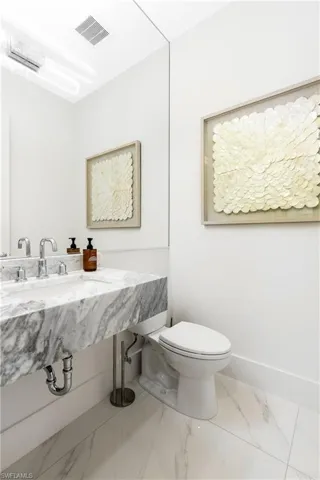 Bathroom featuring marble finish floors and baseboards