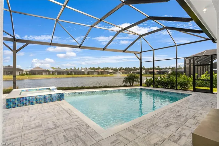View of swimming pool with a sunroom, glass enclosure, a residential view, a patio, and a water view
