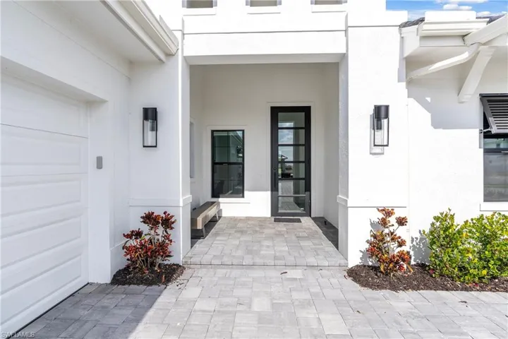 Doorway to property featuring stucco siding and a garage