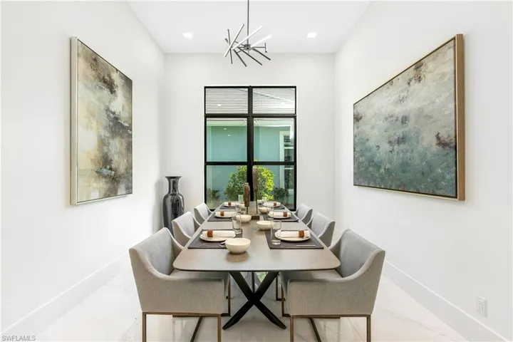 Dining room featuring a chandelier and marble look tiles