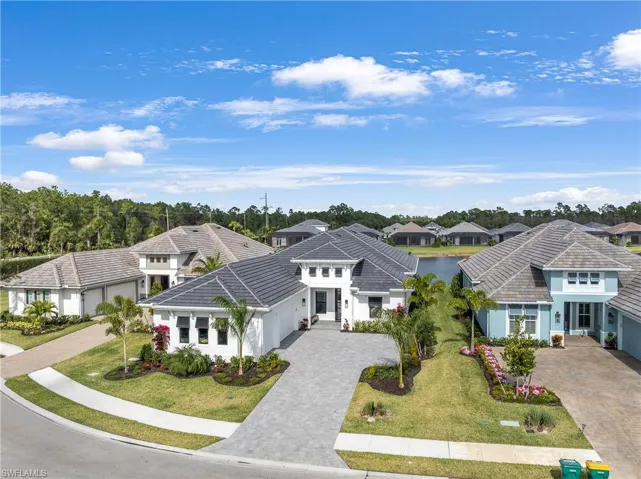 View of front of house with a residential view, decorative driveway, stucco siding, an attached garage, and a front lawn