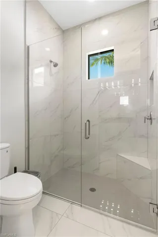 Full bathroom with a marble finish shower and marble finish flooring