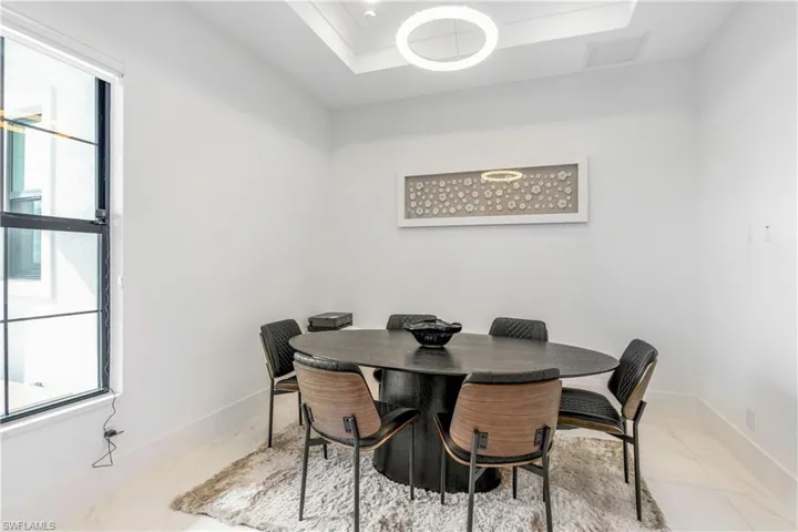 Dining space featuring a raised ceiling and baseboards