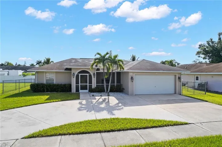 Ranch-style house featuring a front yard and a garage