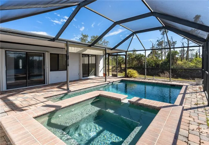 View of pool featuring an in ground hot tub, a patio, and screened enclosure