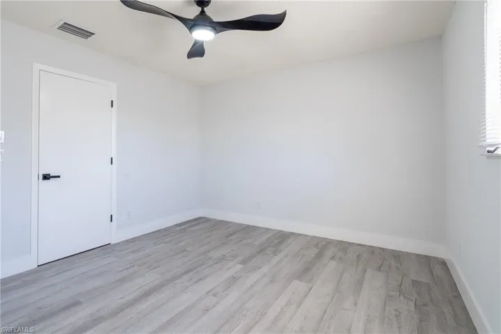 Guest room with light hardwood / wood-style flooring and ceiling fan