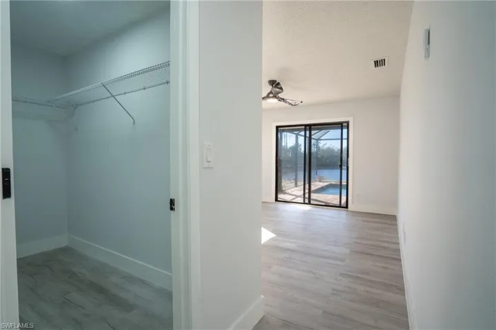 Walk in closet with light wood-type flooring