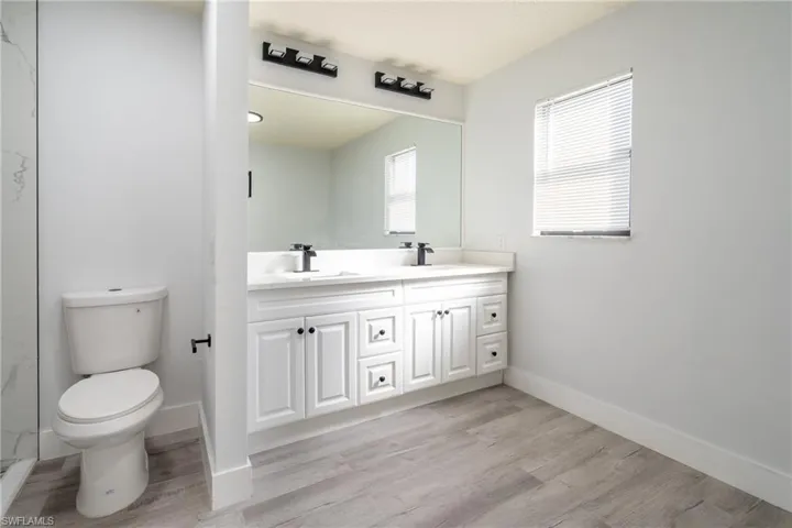Bathroom featuring vanity, hardwood / wood-style flooring, and toilet