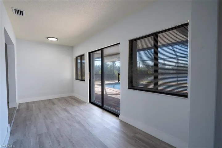 Spare room featuring a textured ceiling and light hardwood / wood-style flooring